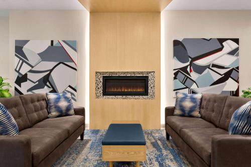 a living room with two couches and a fireplace at Wingate by Wyndham Bronx Haven Park in Bronx