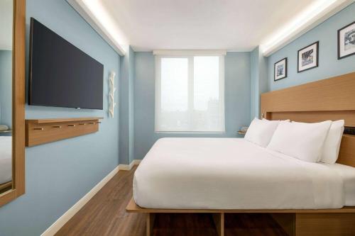 Una cama o camas en una habitación de Wingate by Wyndham Bronx Haven Park