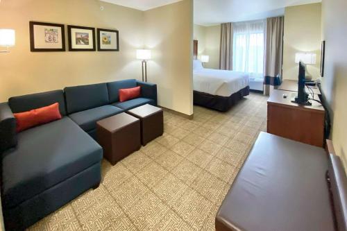 a hotel room with a couch and a bed at Comfort Inn & Suites Harrah 