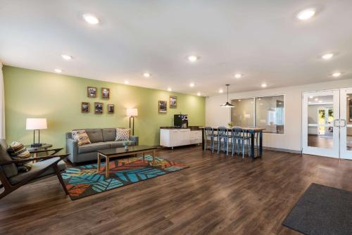 WoodSpring Suites Greensboro - High Point North في جرينسبورو: غرفة معيشة مع أريكة وطاولة