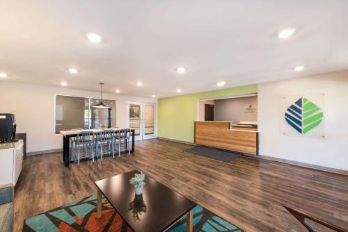 WoodSpring Suites Greensboro - High Point North في جرينسبورو: غرفة معيشة مع مطبخ وغرفة طعام