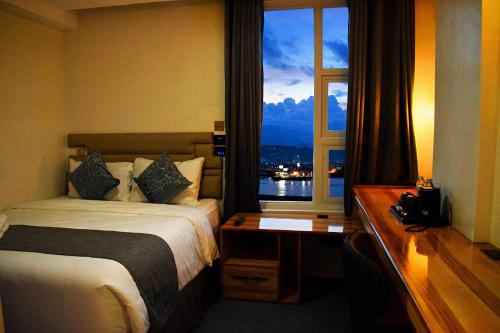 um quarto de hotel com uma cama e uma janela em Sempre Premier Inn - MACTAN AIRPORT HOTEL em Mactan