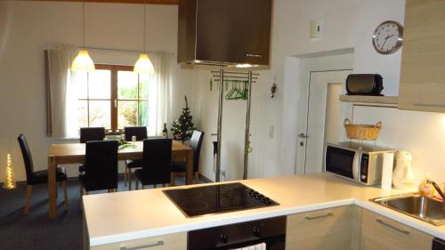 eine Küche und ein Esszimmer mit einem Tisch und einer Mikrowelle in der Unterkunft Haus Masonblick in Braz