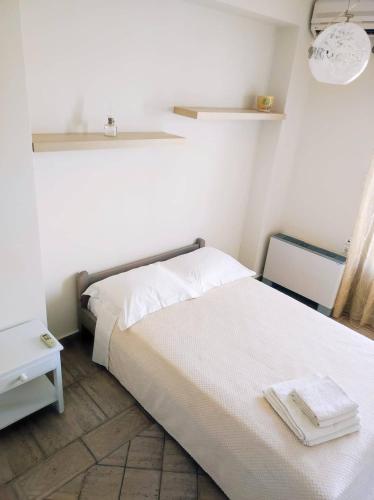 a white bedroom with a bed and a window at 3BD Apartment in the Center - Self check in in Patra