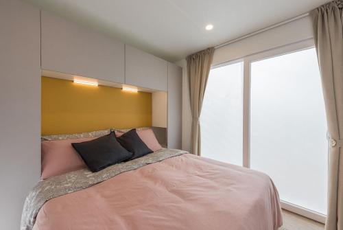 a bedroom with a large bed and a large window at Camping Barco Reale in Lamporecchio