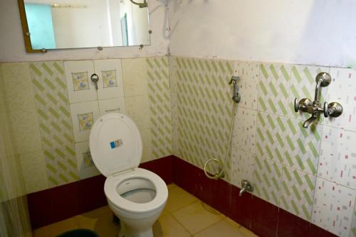 BANARAS REST HOUSE في فاراناسي: حمام مع مرحاض ومرآة