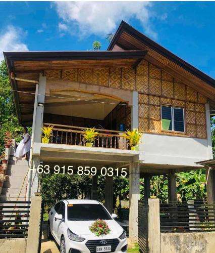 a house with a car parked in front of it at MIOKI HOMETEL in Batuan