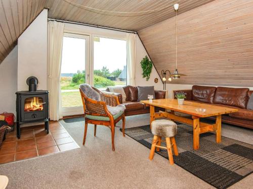 a living room with a couch and a wood stove at 6 person holiday home in Hvide Sande in Hvide Sande