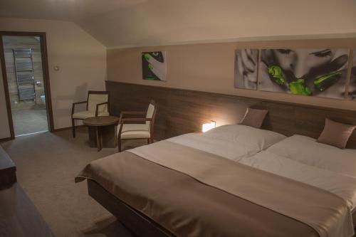 a hotel room with a bed and a table and chairs at Restaurace a Penzion U Klásků in Olomouc