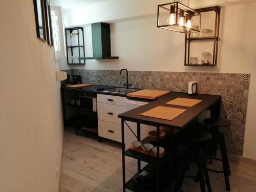 a kitchen with a sink and a table with stools at Loft & Studio Cascais in Cascais
