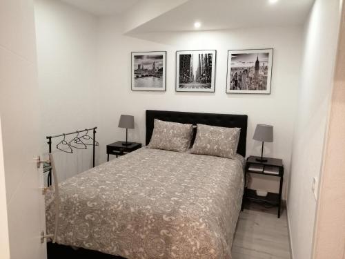ein Schlafzimmer mit einem Bett und drei Bildern an der Wand in der Unterkunft Loft & Studio Cascais in Cascais