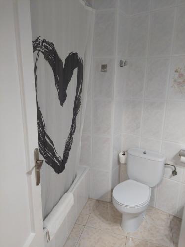 a bathroom with a toilet and a heart painted on the wall at Hotel Cervantes in Mahora