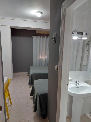 a bathroom with two beds and a sink at Hotel Cervantes in Mahora