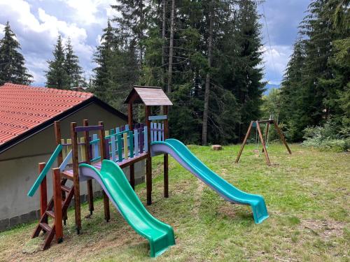 a playground with a slide and a swing set at Guest House Golijski Dar in Dajići