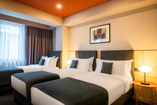 um quarto de hotel com duas camas e uma janela em Reikartz King Tamar Tbilisi em Tbilisi