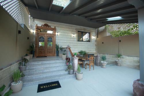 une terrasse couverte avec une porte en bois et une table ornée de plantes dans l'établissement Vila Mariss, à Korçë