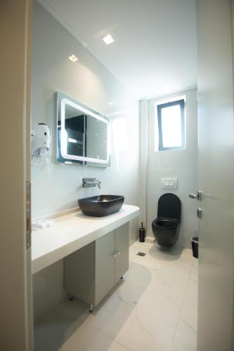 a bathroom with a black toilet and a sink at Vila Mariss in Korçë