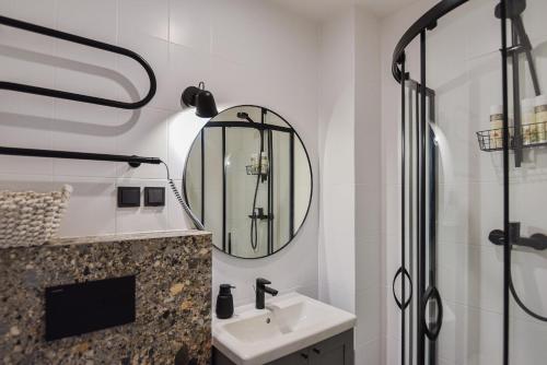 ein Bad mit einem Waschbecken und einem Spiegel in der Unterkunft Apartamentai Ešerinėje in Neringa