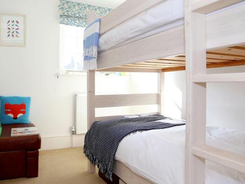 a bedroom with two bunk beds and a window at Half Turn Cottage in Whitstable