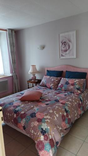 1 dormitorio con 1 cama con un edredón colorido en La Bretagne ça vous gagne, en Ploufragan