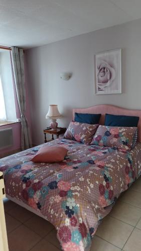 une chambre avec un lit avec une couette colorée dans l'établissement La Bretagne ça vous gagne, à Ploufragan