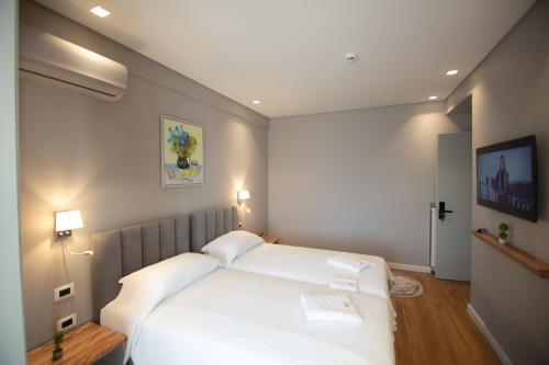 a bedroom with a large white bed with two pillows at Vila Mariss in Korçë