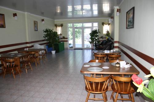 un restaurante con mesas de madera y sillas en una habitación en Elling Briz, en Feodosia