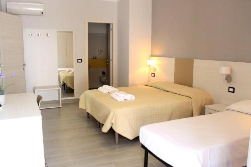 a hotel room with two beds and a bathroom at Meublé Leonetti in Palinuro