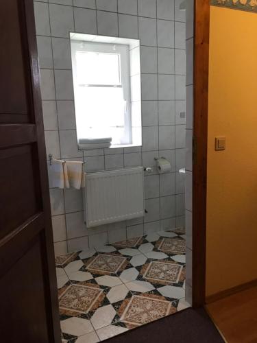 a bathroom with a window and a tile floor at Doppelzimmer vom Friesenhof Wieratal in Nobitz