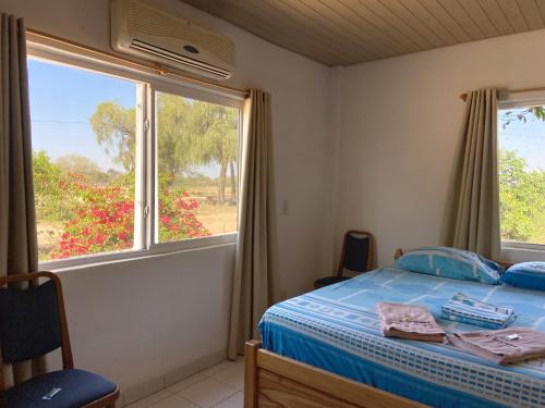 a bedroom with a bed and a window at Hotel Campestre Iparoma in Estancia Campo Aroma