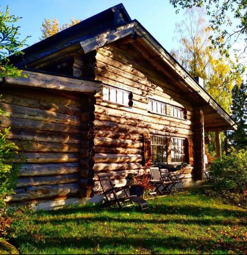 a log cabin with two chairs in front of it at Villa Lilja in Muurame
