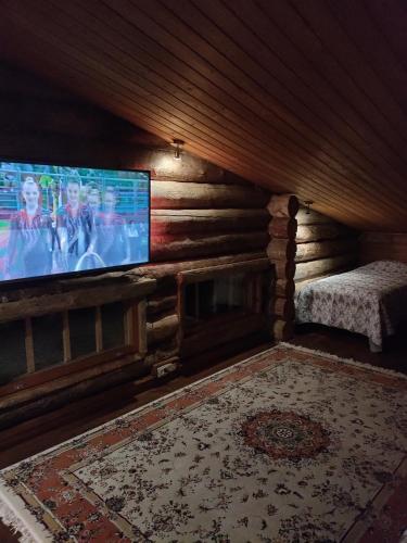 a living room with a flat screen tv in a log cabin at Villa Lilja in Muurame