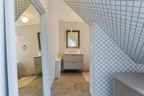 La salle de bains est pourvue d'un lavabo et d'un miroir. dans l'établissement Saulėtasis Rytas, à Nido