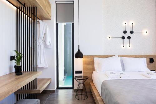 a bedroom with a large bed and a mirror at Physis Villas - Metal & Wood in Pigi