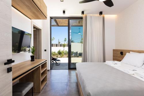 a bedroom with a bed and a sliding glass door at Physis Villas - Metal & Wood in Pigi