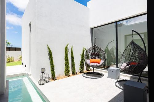 a patio with two chairs and a swimming pool at Physis Villas - Metal & Wood in Pigi