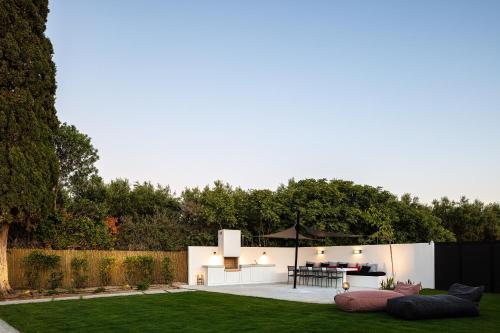 a garden with a table and an umbrella at Physis Villas - Metal & Wood in Pigi