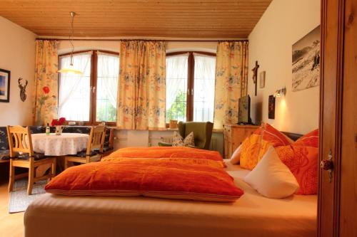 a bedroom with a large bed with orange sheets at Haus Pürner in Reit im Winkl