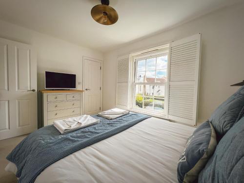 1 dormitorio con 1 cama, TV y ventana en Beach Boutique, en Camber
