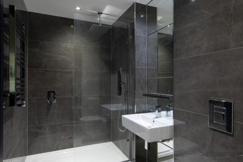 een badkamer met een wastafel en een douche bij Chelsea Cascade London Flat in Londen