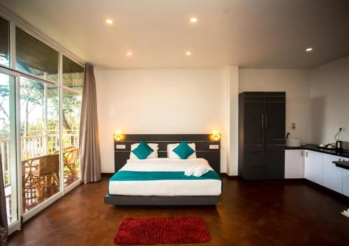 a bedroom with a large bed and a kitchen at Areva Inn Munnar by VOYE HOMES in Munnar