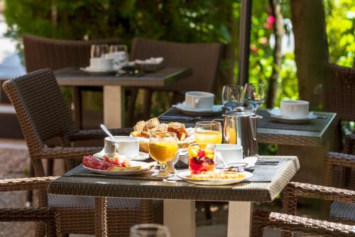 an outdoor table with food and drinks on it at Hôtel Le Mozart in Aix-en-Provence