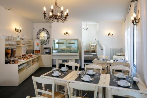 Habitación con mesa, sillas y pecera. en Hôtel Le Mozart, en Aix-en-Provence