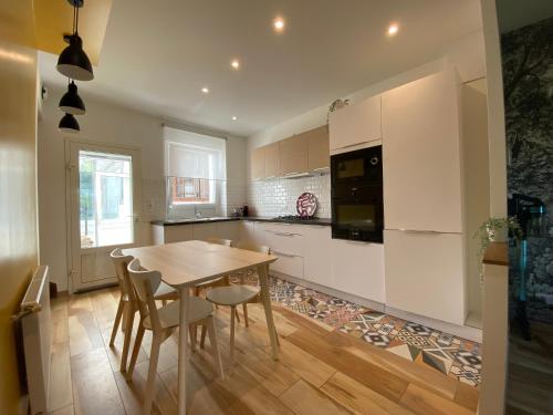 a kitchen with a table and chairs in a room at Maison de ville au bord de l’eau (3) in Saint-Nicolas-de-Port