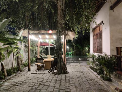 a patio with a table and a tree at Banyan Villa Nha Trang in Nha Trang