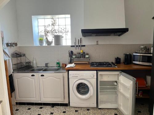 a kitchen with a washing machine and a sink at Gîte de la bastide in Monteux