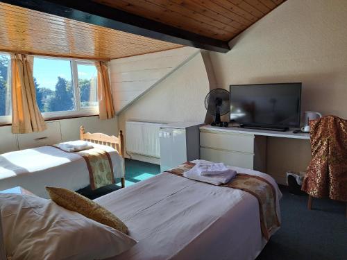 een hotelkamer met 2 bedden en een flatscreen-tv bij Diamond House in Rugby