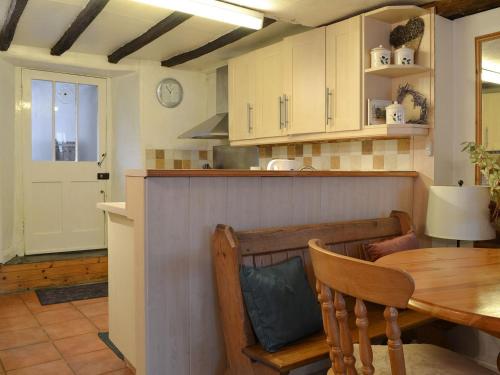 a kitchen with a table and a dining room at Beck Cottage in Ambleside