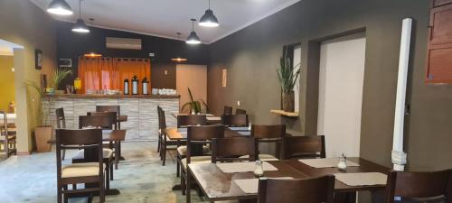 a restaurant with tables and chairs and a bar at HOTEL BL in Puerto Iguazú