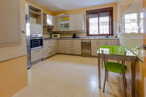 a kitchen with a table and green chairs in it at Villa Viana in Rute